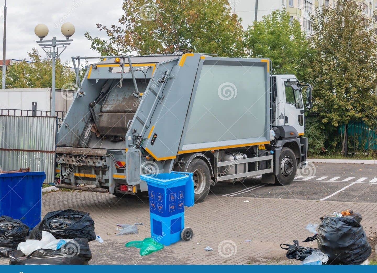 Servicio de recogida de basura, un recolector de residuos que trabaja en el vaciado...
